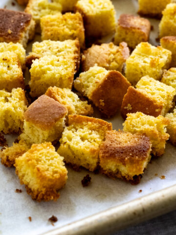 Side, up-close view of cornbread croutons after coming out of the oven.