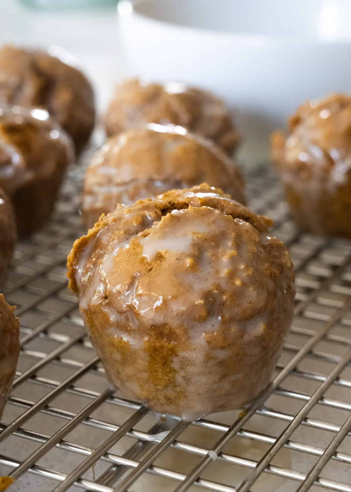 Up close picture of a pumpkin donut hole covered in a sugar glaze.