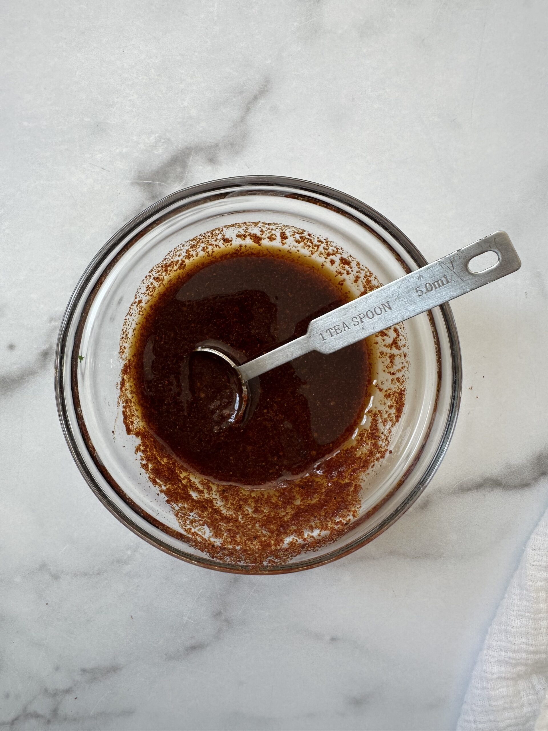 bowl of olive oil, balsamic and spices that will go on chicken thighs.