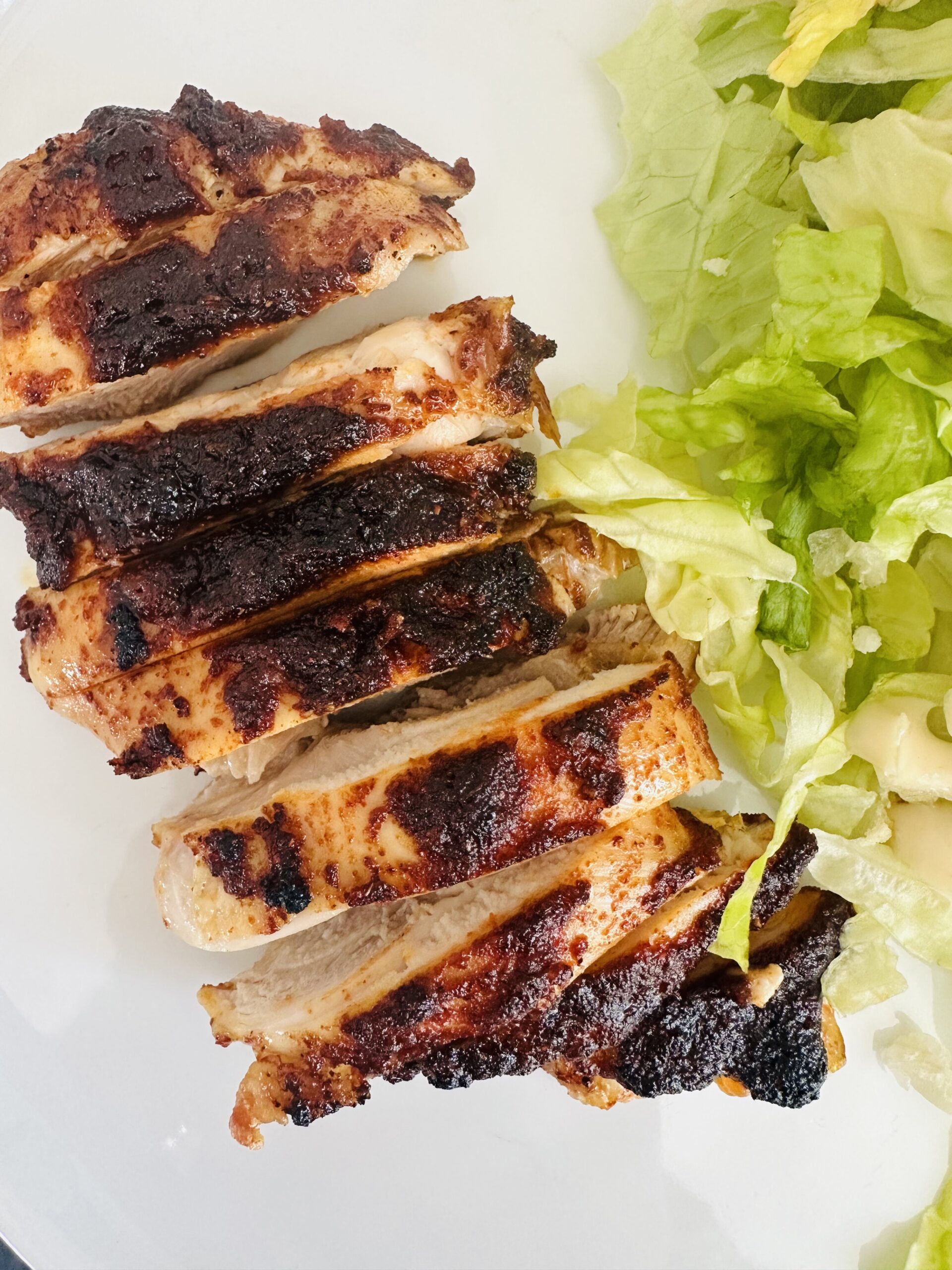 close up picture of seasoned and sliced boneless chicken thighs.